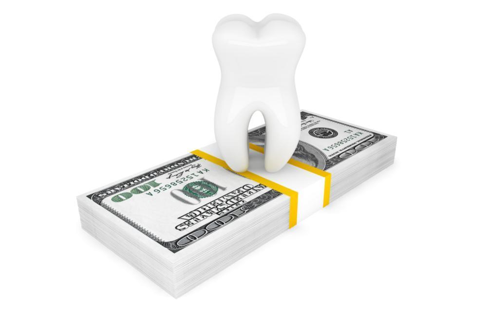 White tooth on top of a stack of money