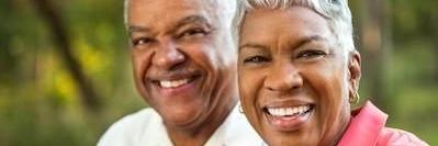 Older couple smiling after gum disease treatment in Apex NC