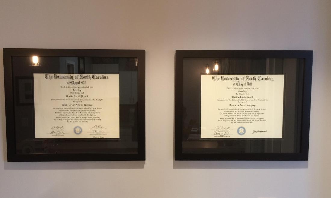 Dr Dustin Prusik DDS diplomas hanging on the wall of Olive Chapel Family Dentistry in Apex