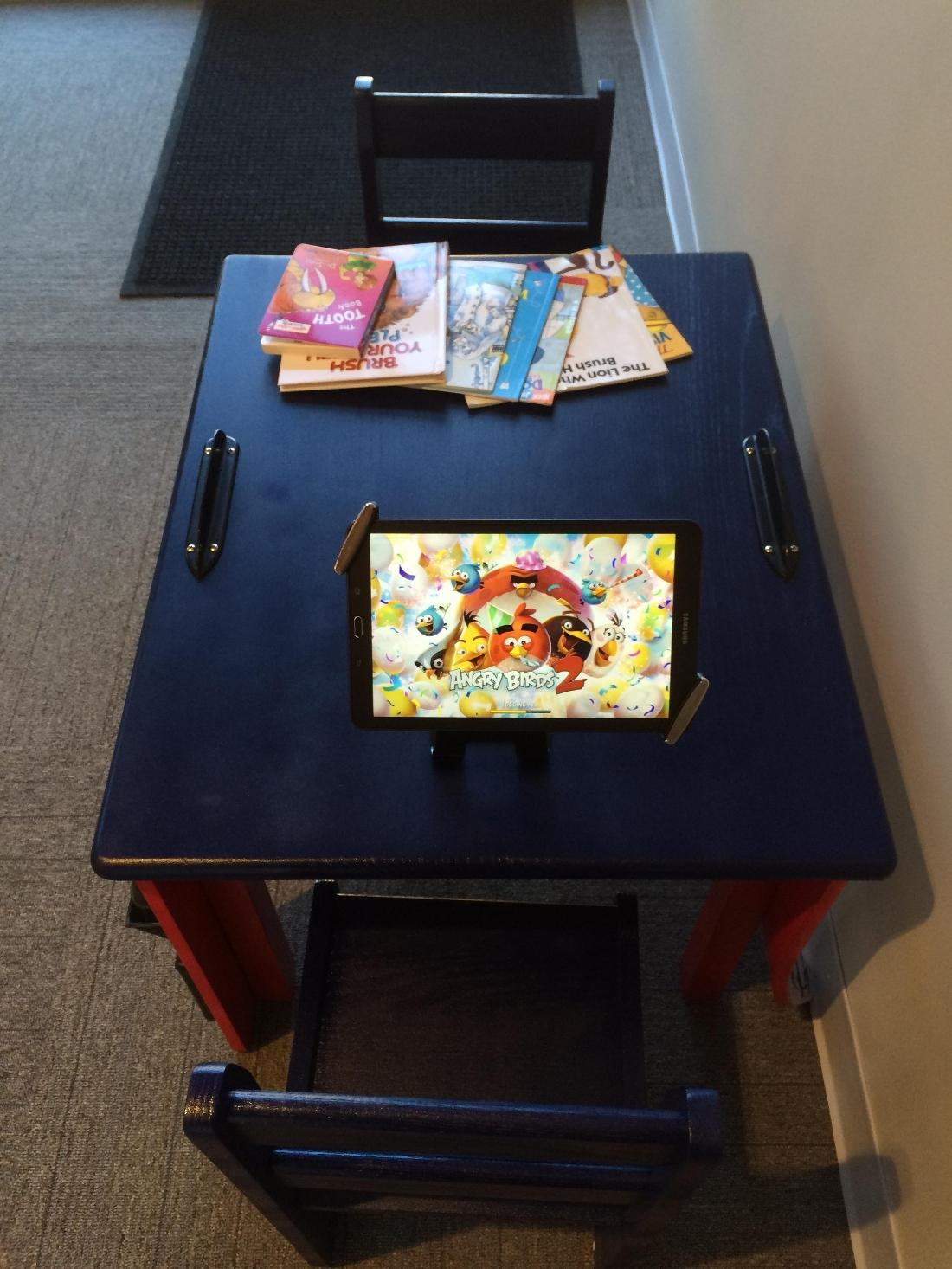 Ipad and books in patient waiting area of our children's dentist in Apex, NC